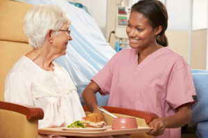 nurse serving meal to an elderly woman